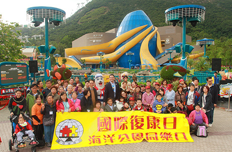 圖1：海洋公園管理及演藝節目執行總監賀倫達先生、香港復康聯會主席張健輝先生及海洋公園吉祥物威威獅令與一眾遊人合照
